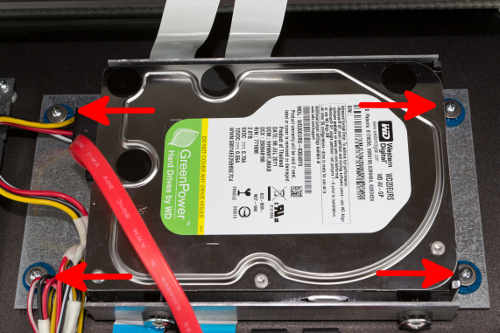 A close up of the hard drive and mounting carriage showing the four screws that must be removed.