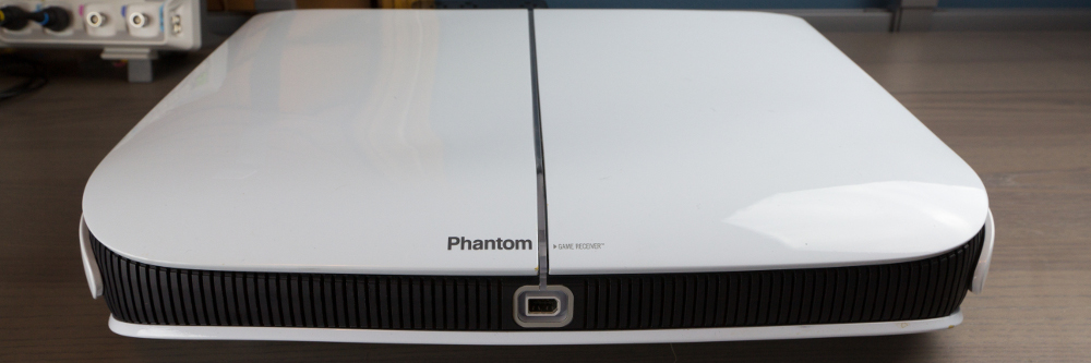 A full view of the front of the Phantom Game Receiver.  The front controller port and light ring are visible.  The text on the console says "Phantom&quote; and &quote;Game Receiver&quote;.